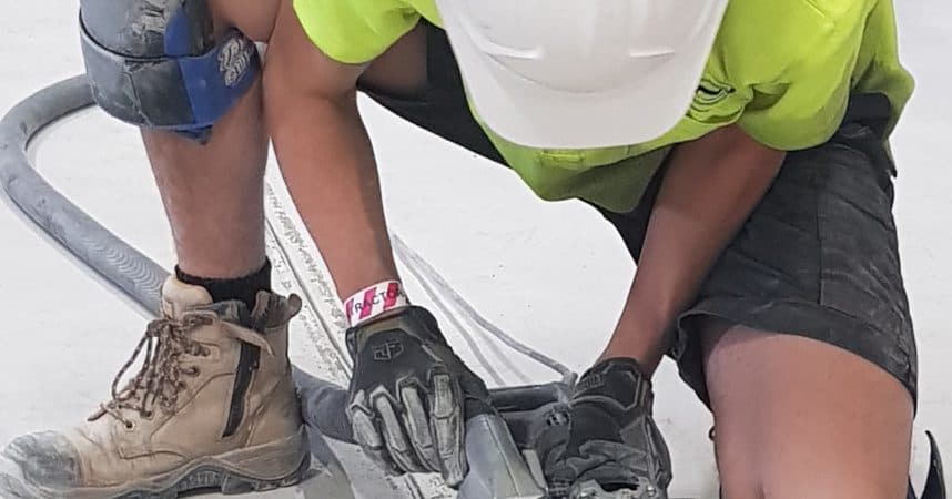 Hand grinder working a concrete edge where the big machine cannot reach