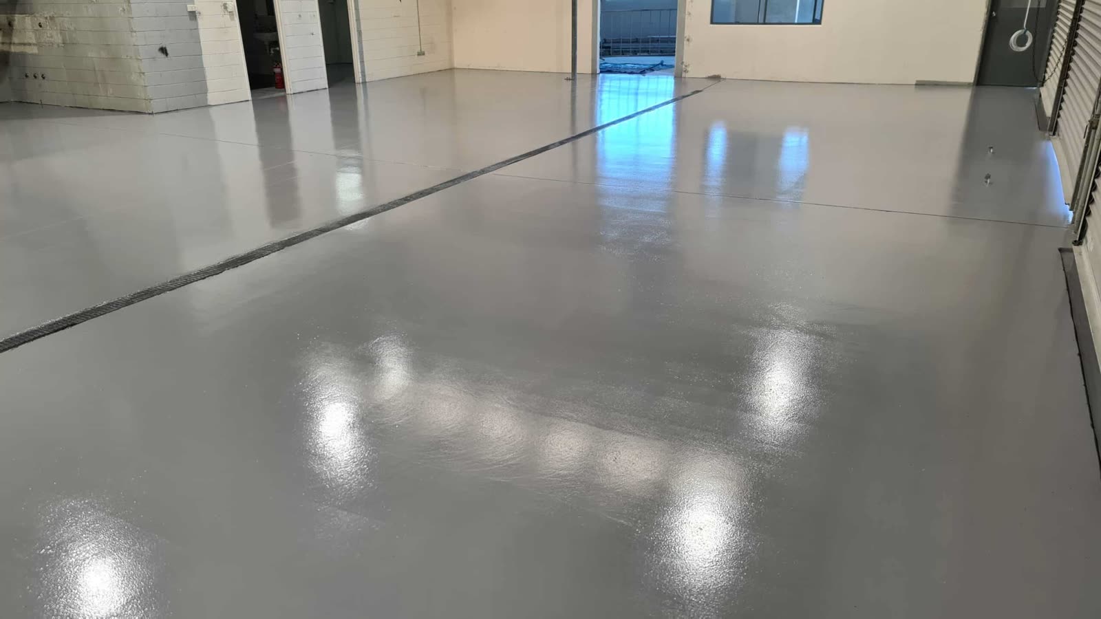 Grey epoxy warehouse floor with a drainage strip, Gold Coast
