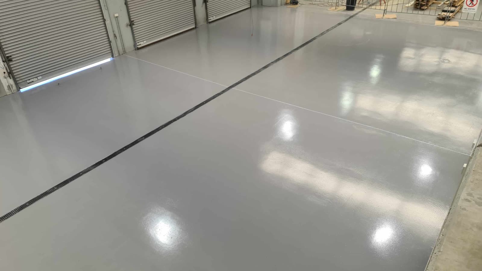 Epoxy floor across a warehouse with roller doors, Gold Coast